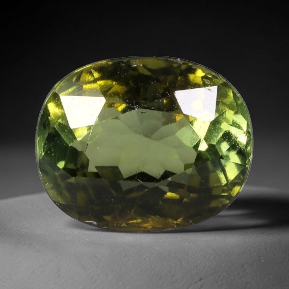 1.68 Carats Deep Olive Green Tourmaline Oval Cut - Natural Loose Gemstone, 68XC: This striking oval-cut tourmaline features a rich deep olive green hue, evoking the earthy warmth of aged forest foliage. Its precision faceting creates a dazzling play of light, with subtle color shi