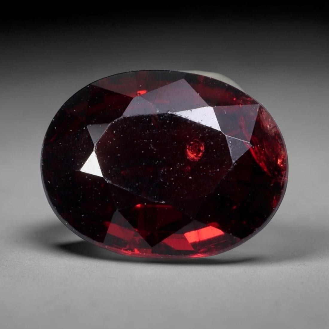 2.52 Carats Deep Red Rhodolite Garnet Oval - Natural Mozambican Stone, 84XY: This singular oval-cut rhodolite garnet, measuring 9.6 x 7.4 x 3.7 mm, radiates with a rich, saturated crimson hue reminiscent of aged wine and pomegranate seeds. Its faceting captures light to reveal