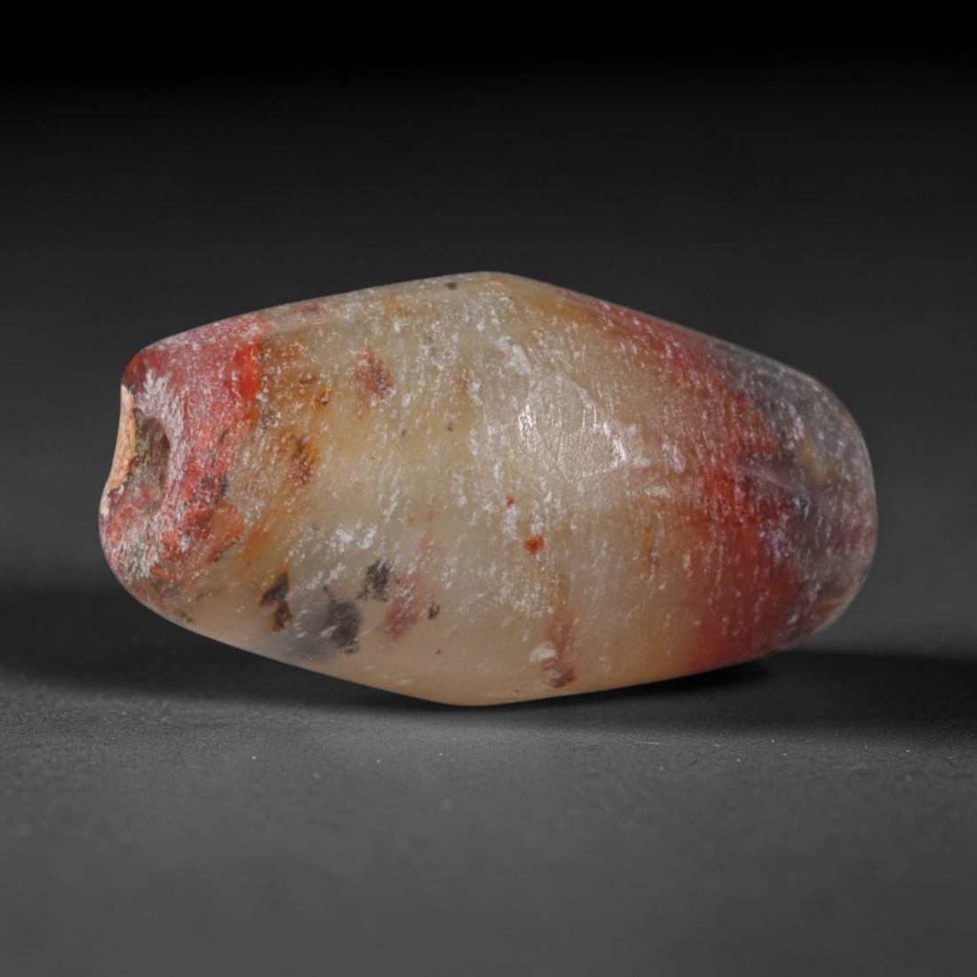 Ancient Mehrgarh Culture Banded Agate Barrel Bead (7000-2600 BCE), 70XD: This antique banded agate barrel bead originates from Mehrgarh Culture, the world's earliest confirmed agate bead workshop civilization located in Balochistan, Pakistan, pioneering primitive pecked dr