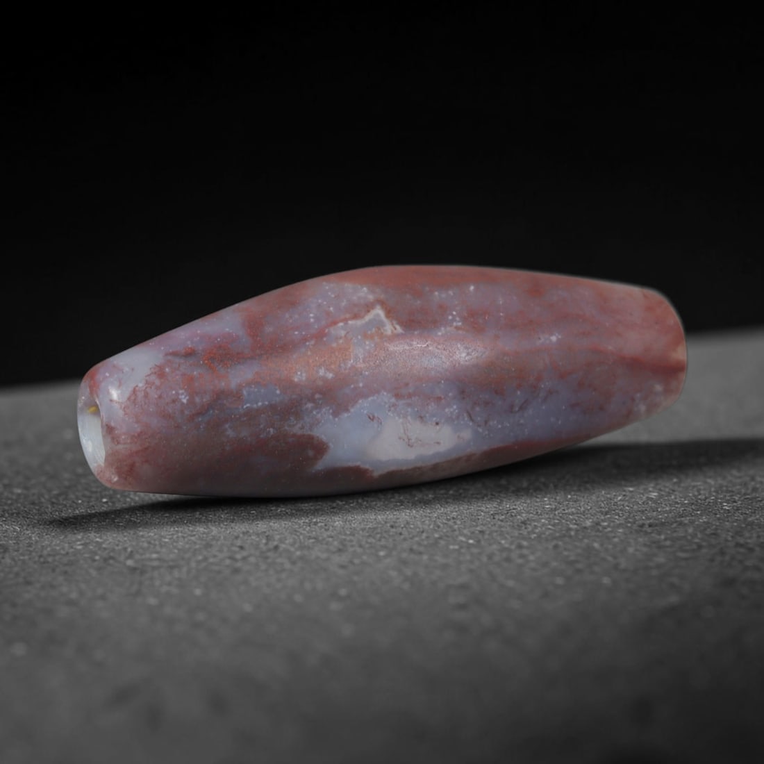 Ancient Indus Valley Civilization Red Moss Chalcedony Bicone Bead (3300-1300 BCE), 100XD: This antique red moss chalcedony bicone bead originates from the Indus Valley Civilization, one of the world's earliest urban societies renowned for fine polished hardstone beads traded across ancient