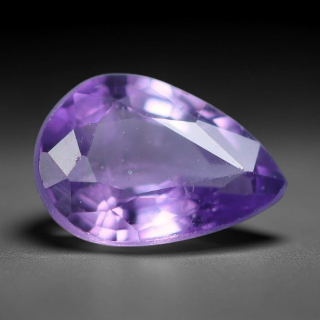 0.40 Carats Natural Purple Sapphire Pear Faceted Loose Gemstone, 65XV: Natural vivid purple corundum sapphire precision cut into a pear faceted loose gemstone, finished with mixed brilliant facets to maximize light return and color saturation. The crystal holds a vibrant