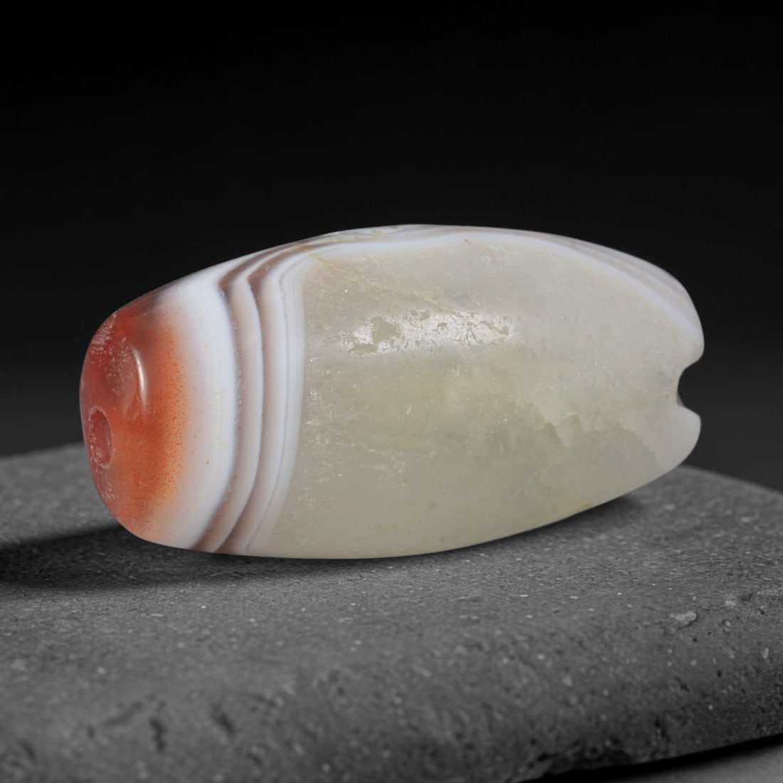 Ancient Phoenician Maritime Banded Carnelian Agate Pebble Bead (1200-300 BCE), 3XV: This antique banded carnelian agate bead originates from Phoenician coastal trading civilizations, master maritime craftsmen who crafted striking two-tone chalcedony adornments for trans-Mediterranean