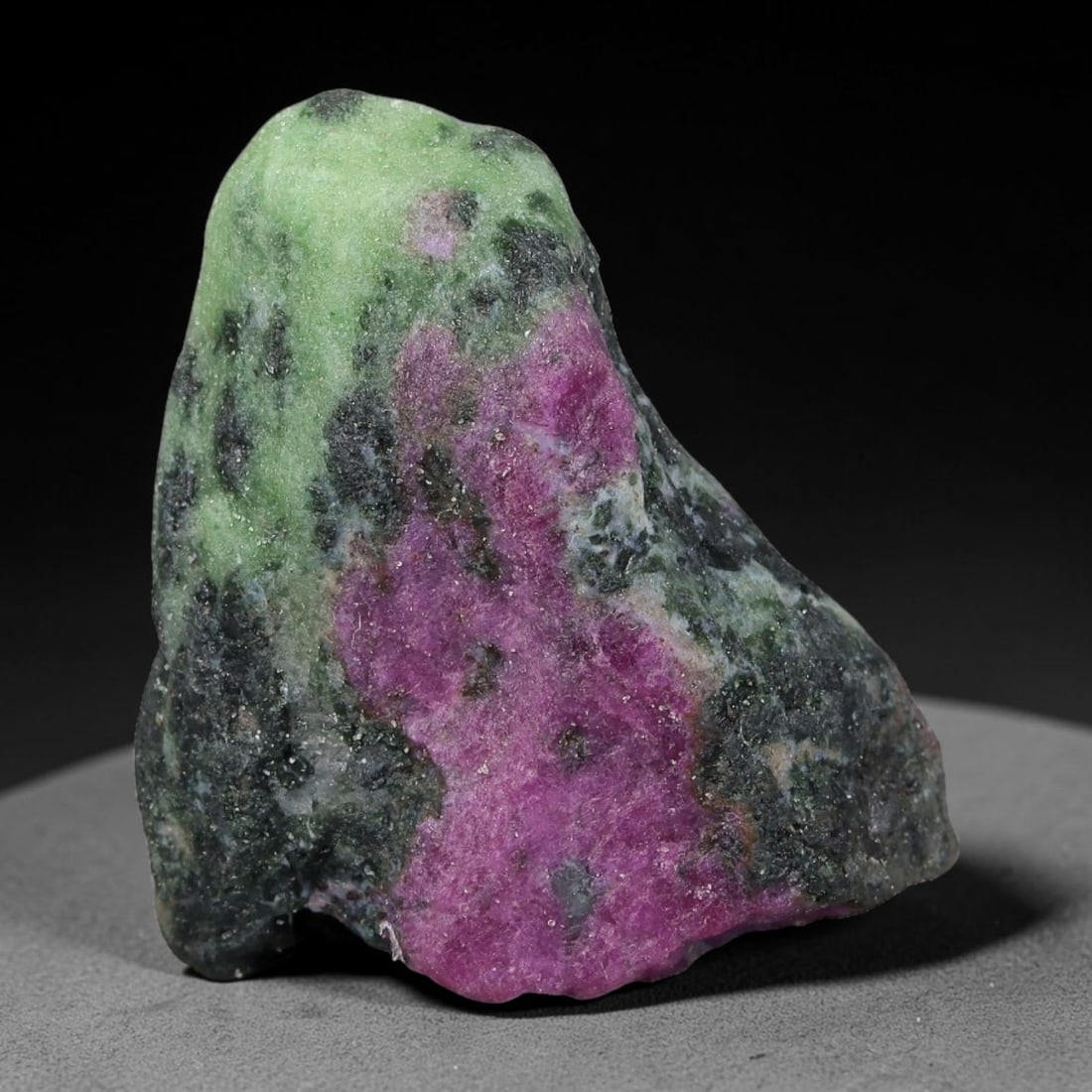 87ct Natural Tanzanian Ruby Zoisite Raw Rough Specimen Mineral Stone, 21YQ: This unpolished mineral rough is natural ruby zoisite sourced from Tanzania, exhibiting distinct banded mineral segregation of vibrant green zoisite, magenta ruby crystals, and dark hornblende inclusi