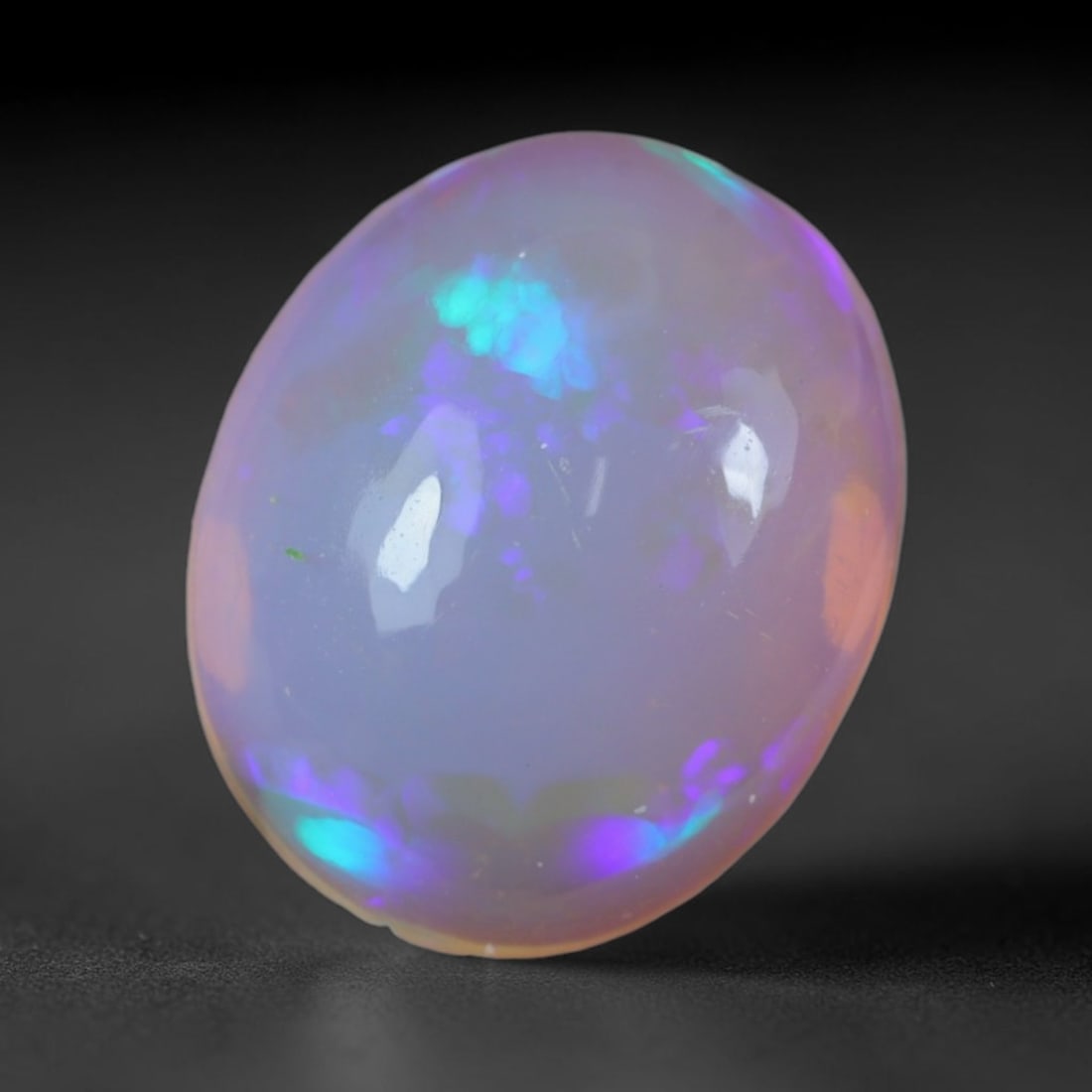 2.34 Carats Natural Ethiopian Welo Opal Oval Cabochon Loose Gemstone, 48XV: Natural Ethiopian Welo opal polished oval cabochon loose gemstone, luminous translucent milky white base stone with vivid multi-hued play-of-color featuring bright emerald green, lime yellow, soft blu