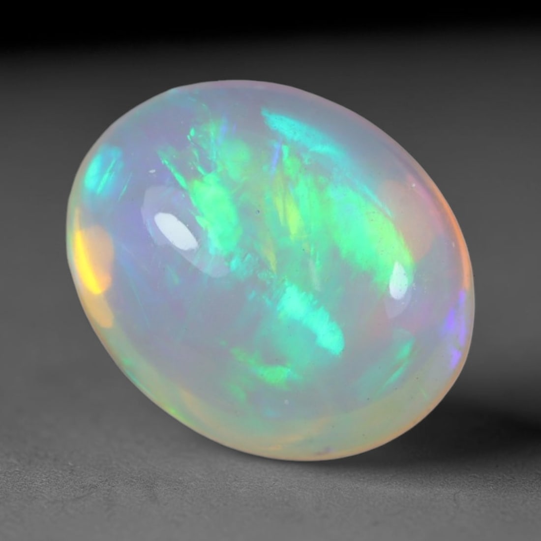 2.12 Carats Natural Ethiopian Welo Opal Oval Cabochon Loose Gemstone, 51XV: Natural Ethiopian Welo opal polished oval cabochon loose gemstone, luminous translucent milky white base stone with vivid multi-hued play-of-color featuring bright emerald green, lime yellow, soft blu