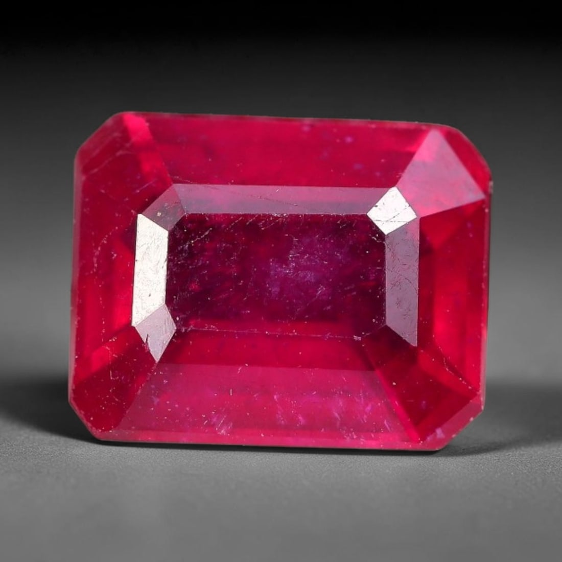 3.07 Carats Natural Madagascar Ruby Emerald Cut Loose Gemstone, 83XM: This natural Madagascar ruby is fashioned in a traditional emerald step faceted cut, showcasing deep saturated red tones typical of Malagasy corundum. Distinct natural internal fissures, fine mineral 
