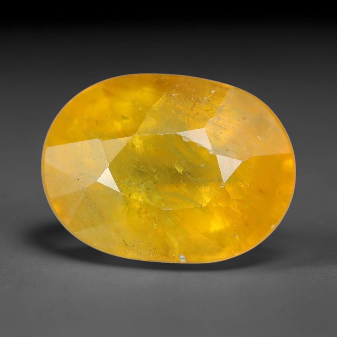 4.26 Carats Natural Yellow Sapphire Oval Faceted Loose Gemstone, 87XM: This natural yellow sapphire features a classic oval brilliant faceted cut, holding consistent warm golden-yellow color throughout the corundum crystal. Fine microscopic mineral specks and faint natur