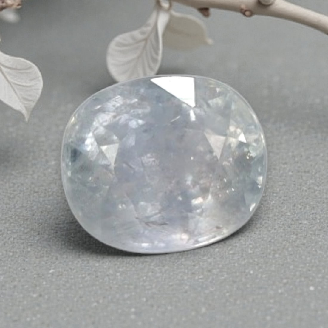 1.24ct Natural Pale Lavender Heated Sapphire Oval Loose Faceted Gemstone, 6YG: This natural oval faceted heated sapphire weighs 1.24 carats with precise dimensions of 6.4x5.5x3.8mm. It features a soft, muted pale lavender-clear translucent base tone, with faint cool grey-blue un