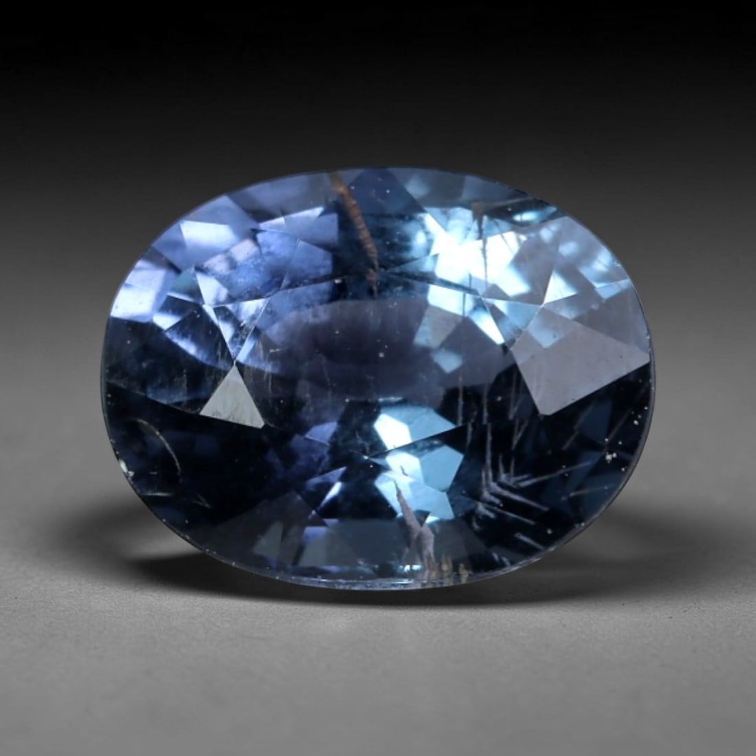 1.28ct Natural Heated Blue Sapphire Oval Loose Gemstone, LZ536: This natural oval faceted blue sapphire weighs 1.28 carats, with exact dimensions of 7.2x5.6x4.1mm. It displays a rich, saturated cool steel-blue hue accented by faint violet undertones, brought to li