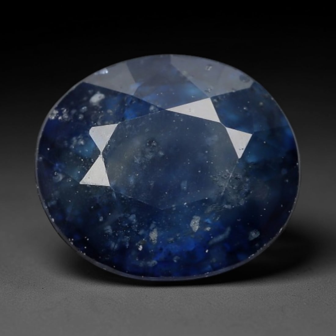 1.24ct Natural Layered Steel Blue Oval Sapphire Loose Faceted Gemstone, LZ304: This natural oval faceted sapphire weighs 1.24 carats with exact dimensions of 6.7x5.8x3.5mm. It displays beautiful layered steel blue hues, blending deep navy blue edges with translucent pale blue-gr