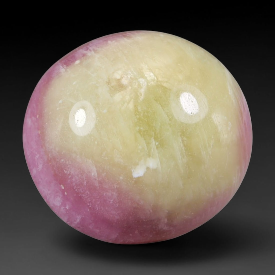 16.84 Carats Natural Madagascar Bi-Color Pink Yellow Heated Ruby Cabochon Loose Gemstone, 100WC: This bi-color ruby cabochon holds sweeping blended zones of soft pastel pink and pale buttery yellow across its polished domed surface, with natural fine mineral veining and faint crystalline texture 