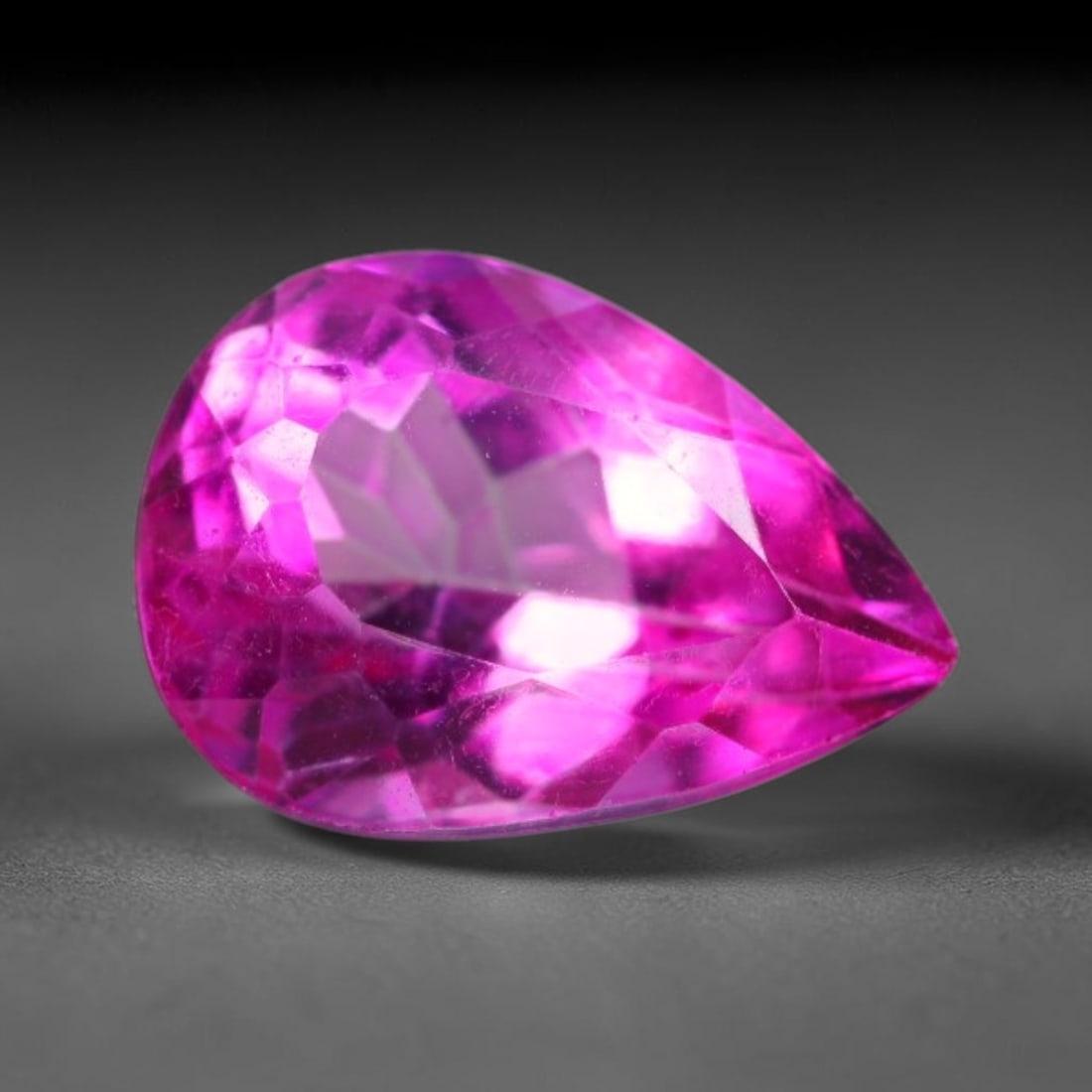 5.01 Carats Natural Vivid Pink Topaz Pear Faceted Loose Gemstone, 8WS: This sleek pear faceted pink topaz displays vivid saturated hot pink color glowing through precisely polished facets, with faint minor natural internal fine textures visible inside the transparent cry