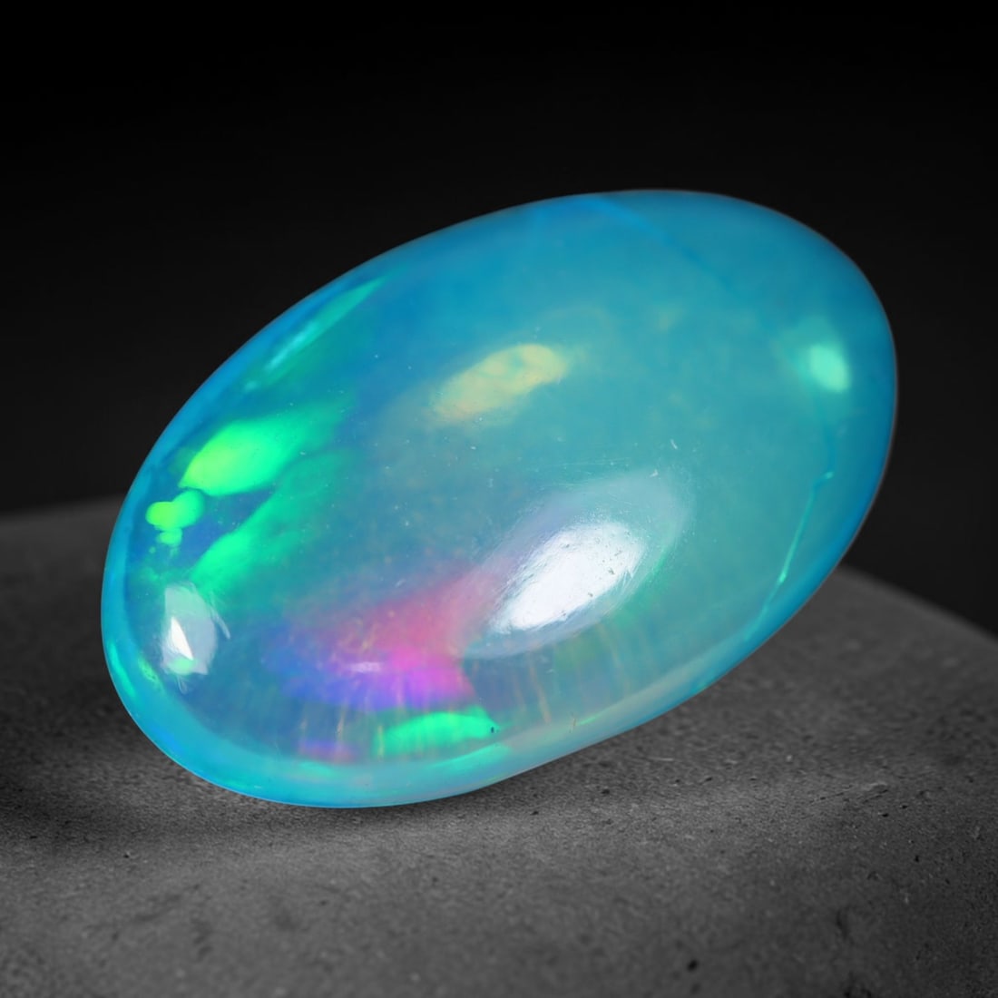 3.25 Carats Natural Ethiopian Welo Blue Base Oval Cabochon Opal Loose Gemstone, 98WS: This smooth polished oval cabochon Ethiopian Welo opal features a dreamy translucent sky-blue base stone, adorned with vivid rolling play-of-color showcasing bright lime green, neon yellow and soft la