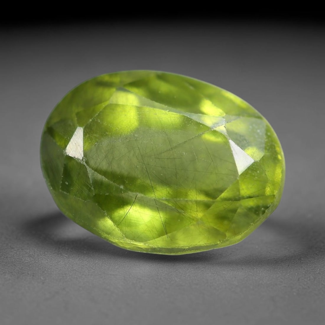 2.80 Carats Natural Green Rutilated Peridot Oval Faceted Loose Gemstone, 68WS: This classic oval faceted peridot features a soft translucent pale olive green crystal filled with striking clusters of dark brown and black rutile needle silk that crisscross throughout the stone, wi