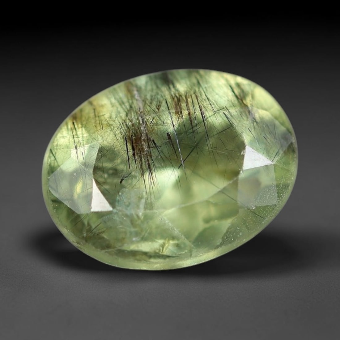 1.64 Carats Natural Green Rutilated Peridot Oval Faceted Loose Gemstone, 72WS: This classic oval faceted peridot features a soft translucent pale olive green crystal filled with striking clusters of dark brown and black rutile needle silk that crisscross throughout the stone, wi