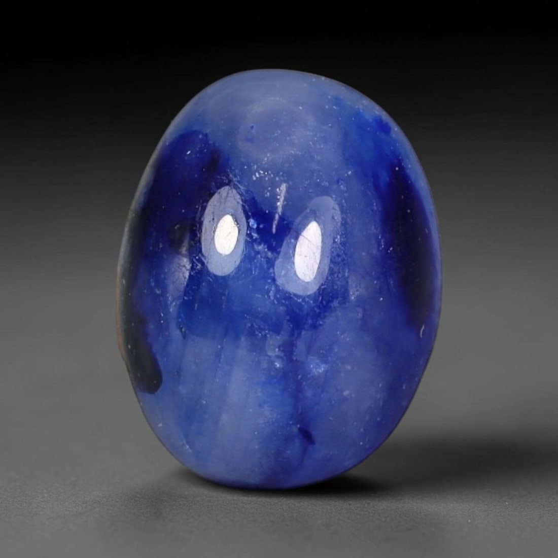 3.31 Carats Natural Two-Tone Royal Blue Sapphire Oval Cabochon Loose Gemstone, 90WS: This smooth domed oval cabochon sapphire showcases dramatic natural two-tone blue color zoning, featuring bold patches of deep saturated royal blue layered over a soft milky sky-blue translucent base.