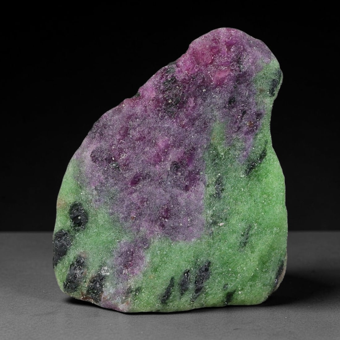 92ct Natural Tanzanian Ruby Zoisite Raw Rough Specimen Mineral Stone, 14YQ: This unpolished mineral rough is natural ruby zoisite sourced from Tanzania, exhibiting distinct banded mineral segregation of vibrant green zoisite, magenta ruby crystals, and dark hornblende inclusi
