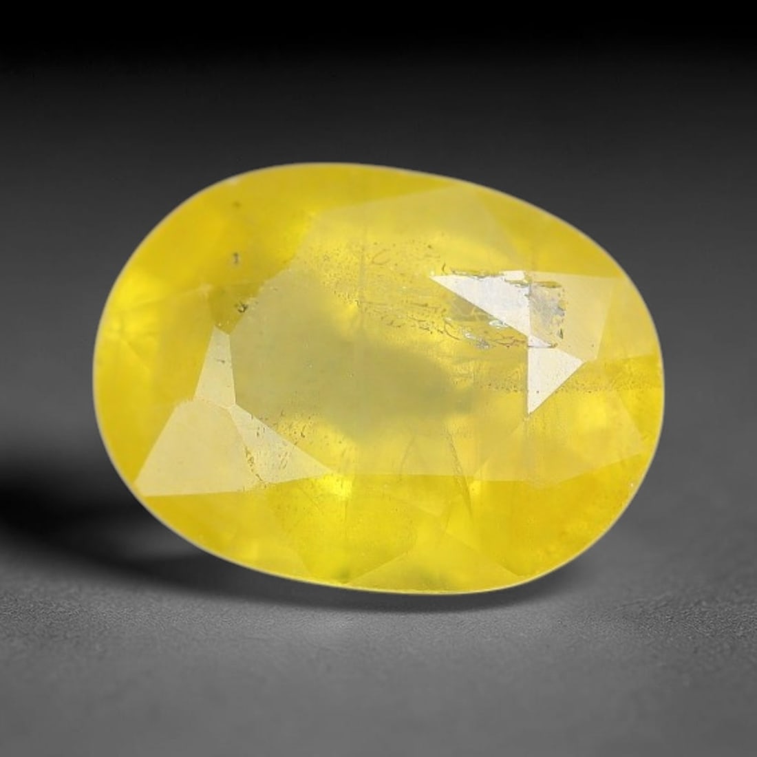 1.98 Carats Natural Yellow Sapphire Oval Faceted Loose Gemstone, 88XM: This natural yellow sapphire features a classic oval brilliant faceted cut, holding consistent warm golden-yellow color throughout the corundum crystal. Fine microscopic mineral specks and faint natur