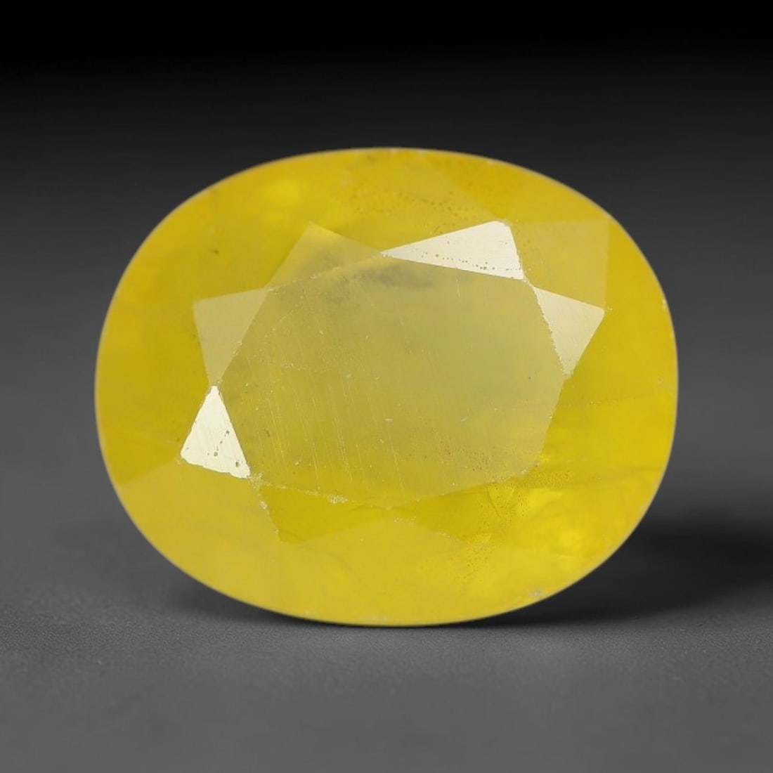 3.90 Carats Natural Yellow Sapphire Oval Faceted Loose Gemstone, 65XM: This natural yellow sapphire features a classic oval brilliant faceted cut, holding consistent warm golden-yellow color throughout the corundum crystal. Fine microscopic mineral specks and faint natur