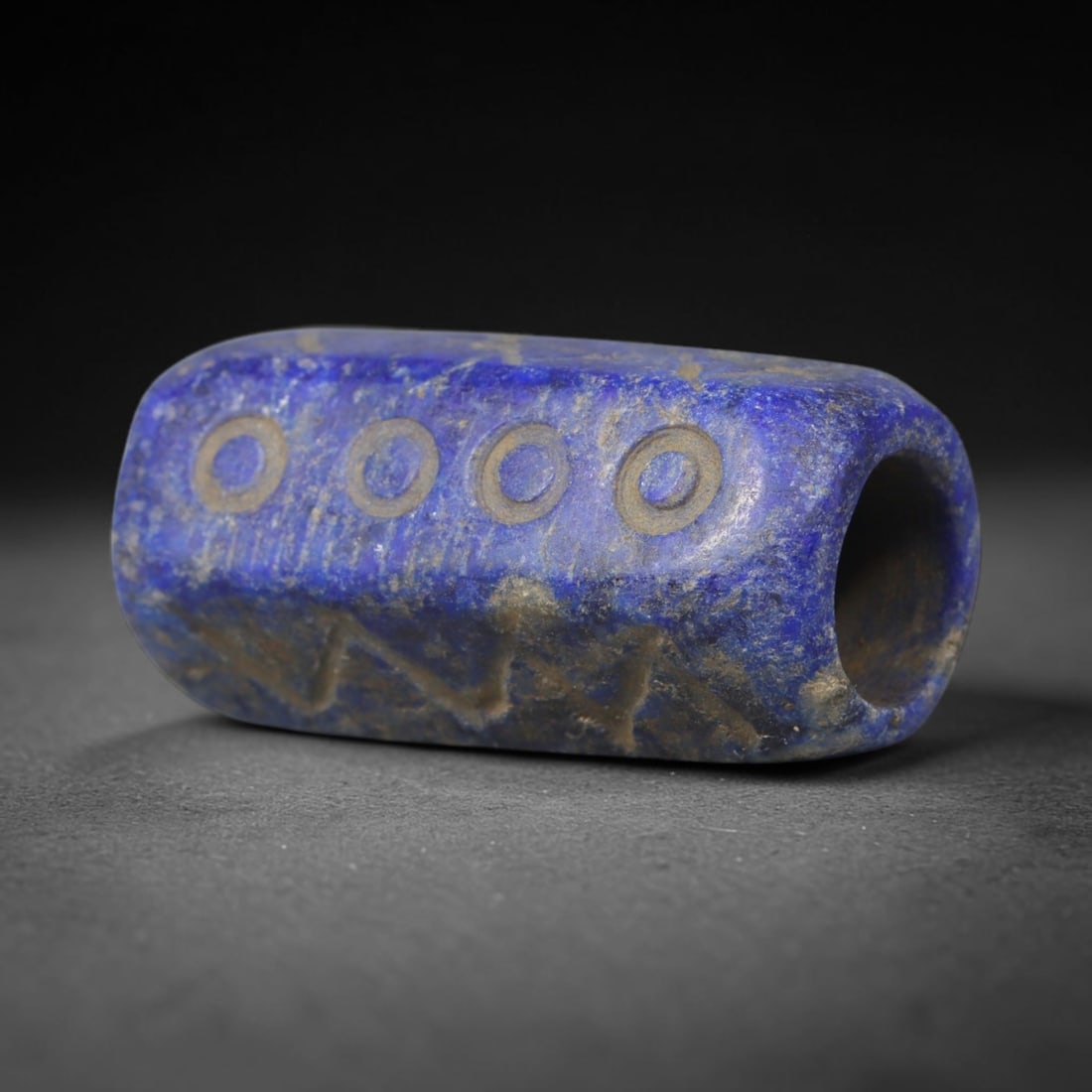 Ancient Lapis Lazuli Bead - Near Eastern Carved Talisman, 26WT: Fashioned from solid lapis lazuli stone, this tubular bead bears hand-incised decorative motifs across its exterior surfaces, rendered with simple incised linework typical of regional stone craft. The