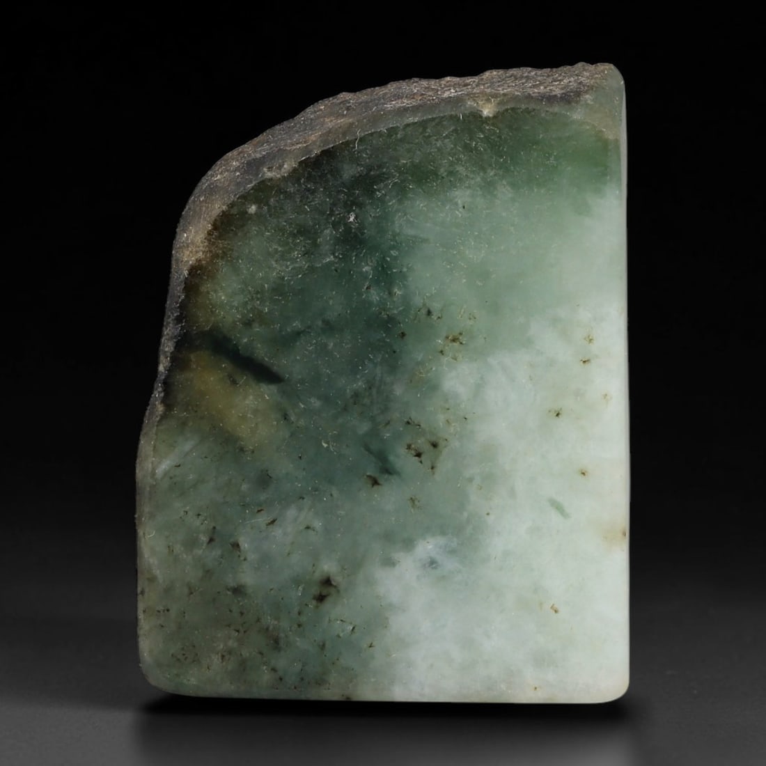 285ct Natural Type A Burmese Jadeite Jade Sliced Rough, 35YR: This specimen is a sliced rough block of natural Type A Burmese jadeite jade. The interior displays natural colour zoning with visible mineral veining and crystalline patterns typical of unprocessed j