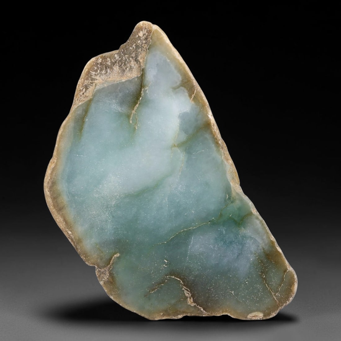 405ct Natural Type A Burmese Pale Aqua Translucent Jadeite Jade Sliced Rough, 55YN: This specimen is a natural sliced rough slab of untreated Type A Burmese jadeite, retaining weathered earth-toned outer rind along its uneven perimeter edge with a polished interior face displaying se