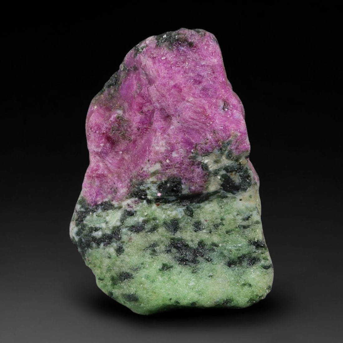 107ct Natural Tanzanian Ruby Zoisite Raw Rough Specimen Mineral Stone, 9YQ: This unpolished mineral rough is natural ruby zoisite sourced from Tanzania, exhibiting distinct banded mineral segregation of vibrant green zoisite, magenta ruby crystals, and dark hornblende inclusi
