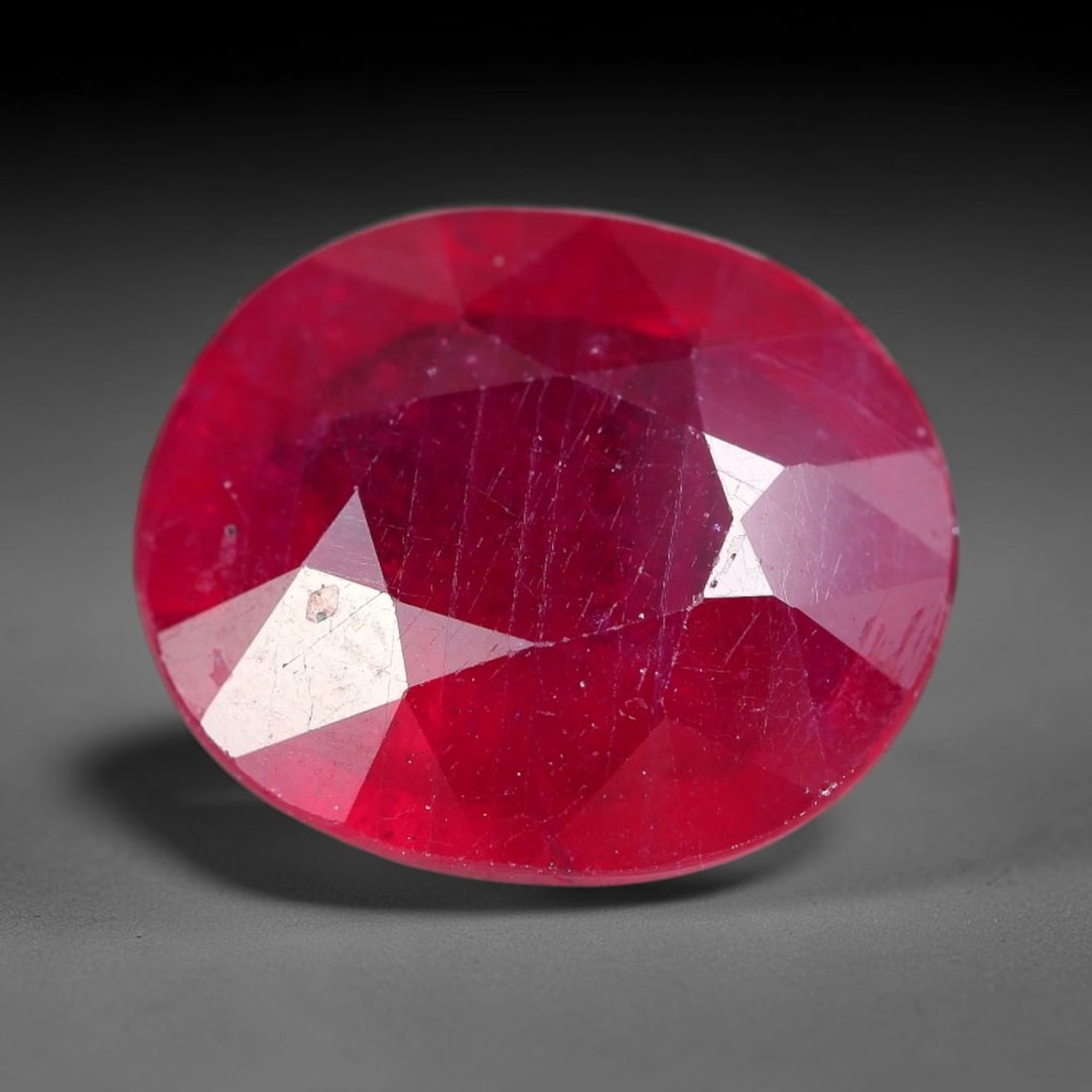 7.61 Carats Natural Madagascar Ruby Oval Faceted Loose Gemstone, 43XM: This sizable natural Madagascar ruby is cut into an oval brilliant faceted form, showcasing rich saturated crimson red hue characteristic of Malagasy corundum. Extensive natural internal silk veining,