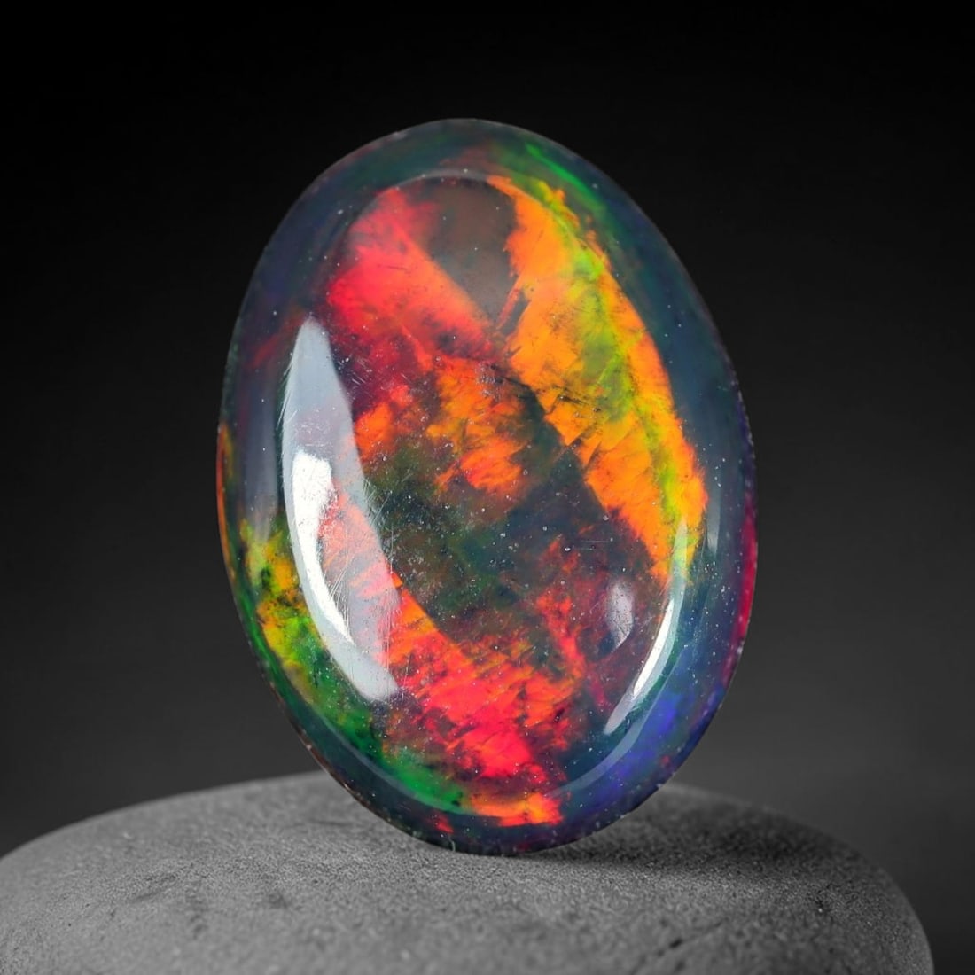 1.26ct Natural Ethiopian Welo Black Smoked Opal Cabochon Loose Gemstone, 91WP: This fully polished Ethiopian Welo opal features a dark smoked base with vivid, sweeping play-of-color shifting across its glossy dome surface, measured at 10.7x8.7x3.0mm. The black smoke treatment de