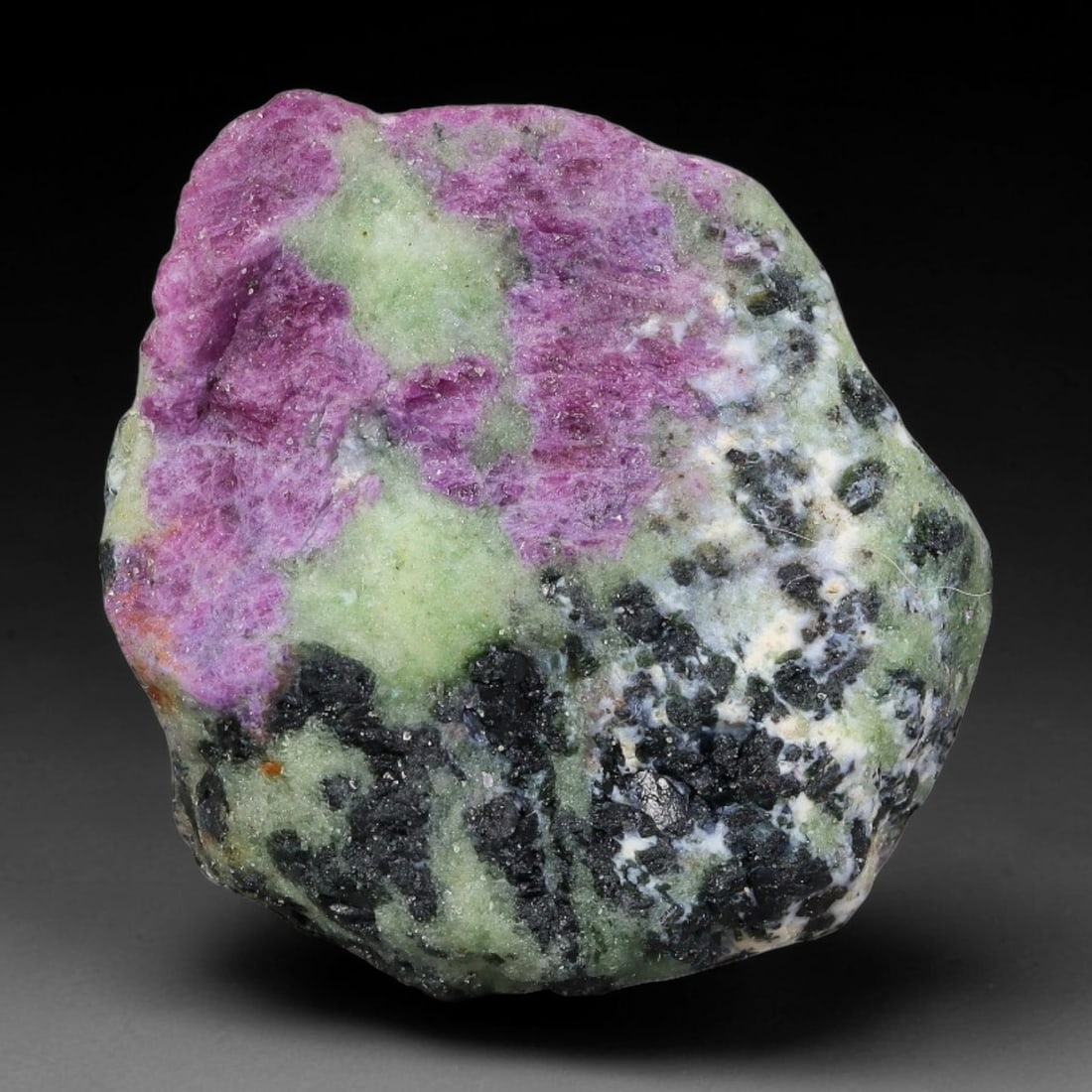 103ct Natural Tanzanian Ruby Zoisite Raw Rough Specimen Mineral Stone, 1YQ: This unpolished mineral rough is natural ruby zoisite sourced from Tanzania, exhibiting distinct banded mineral segregation of vibrant green zoisite, magenta ruby crystals, and dark hornblende inclusi