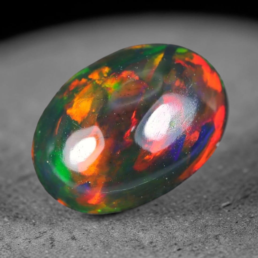 1.38ct Natural Ethiopian Welo Black Smoked Opal Cabochon Loose Gemstone, 84WP: This fully polished Ethiopian Welo opal features a dark smoked base with vivid, sweeping play-of-color shifting across its glossy dome surface, measured at 9.5x7.0x4.0mm. The black smoke treatment dee