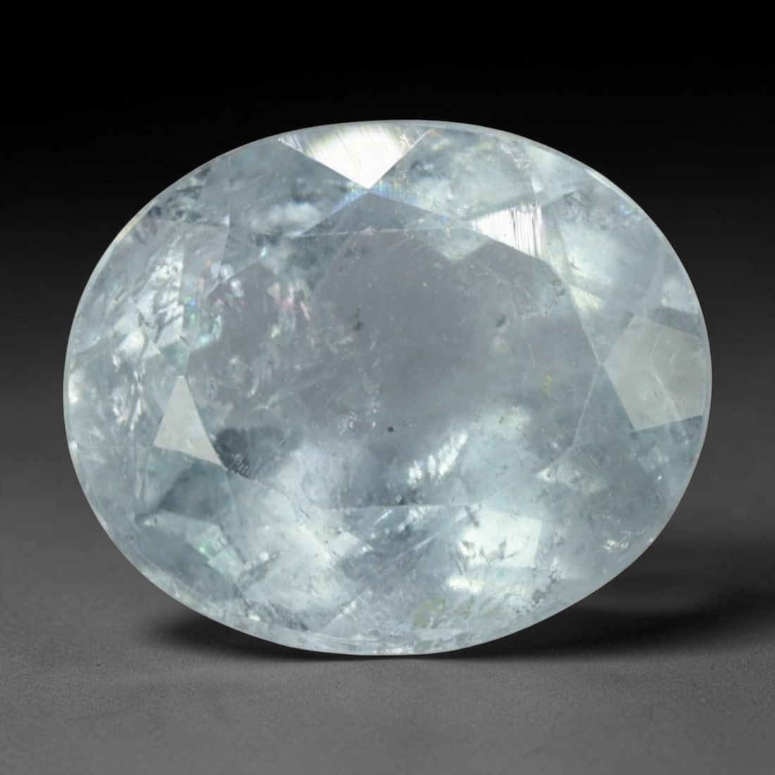 4.29 Carats Pale Sky Blue Aquamarine Oval - Natural Brazilian Stone, 78XC: This luminous oval-cut aquamarine evokes the tranquil tones of a clear sky, with a soft, pale blue hue that radiates gentle serenity. The stone's faceted cut catches light beautifully, creating a subt