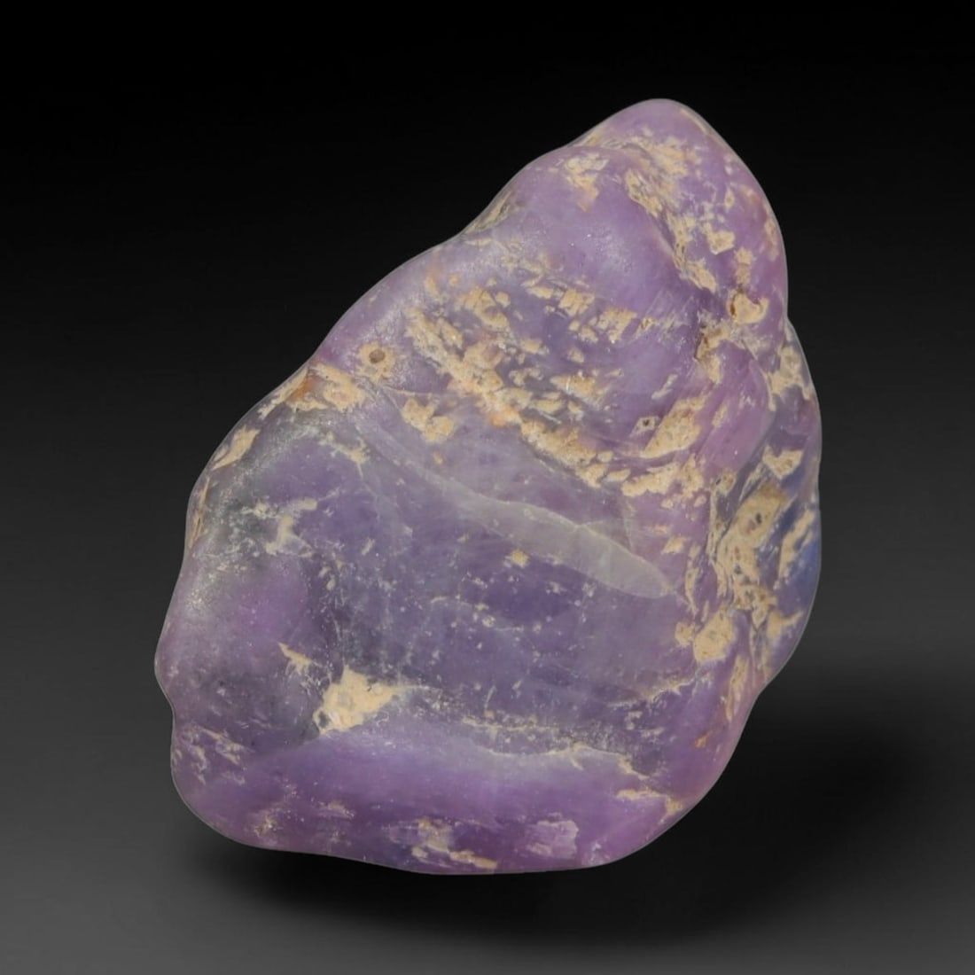 22ct Natural Unheated Sri Lankan Purplish Blue Sapphire Rough, 64YQ: This natural corundum rough is an unheated purplish blue sapphire sourced from Sri Lankan alluvial gem deposits, featuring an irregular natural native form with residual pale yellow-brown mineral matr