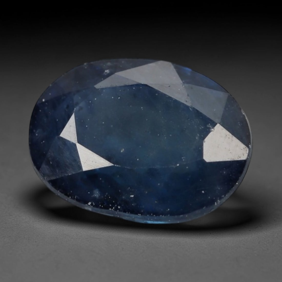 1.51ct Natural Madagascar Soft Steel Blue Sapphire Oval Loose Faceted Gemstone, LZ297: This natural oval faceted sapphire mined in Madagascar weighs 1.51 carats with precise dimensions of 7.7x5.9x3.3mm. It features a muted soft steel-blue primary hue, with subtle translucent greyish und