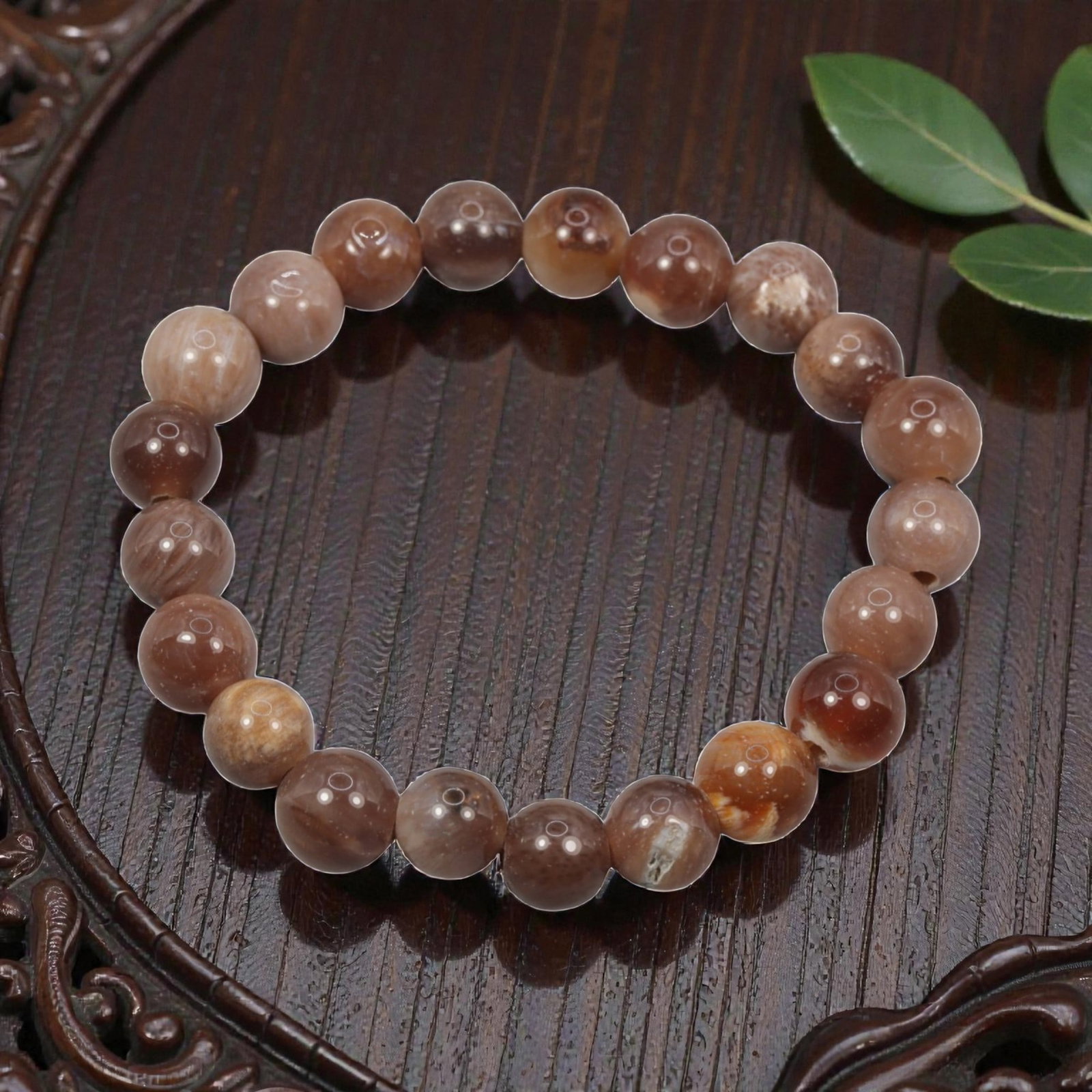 A Fossilised Wood Bead Bracelet, 54ZK: Composed of a single strand of spherical fossilised wood beads forming a circular bracelet. The beads display natural tonal variation from pale beige to deep brown, with visible linear wood-grain patt