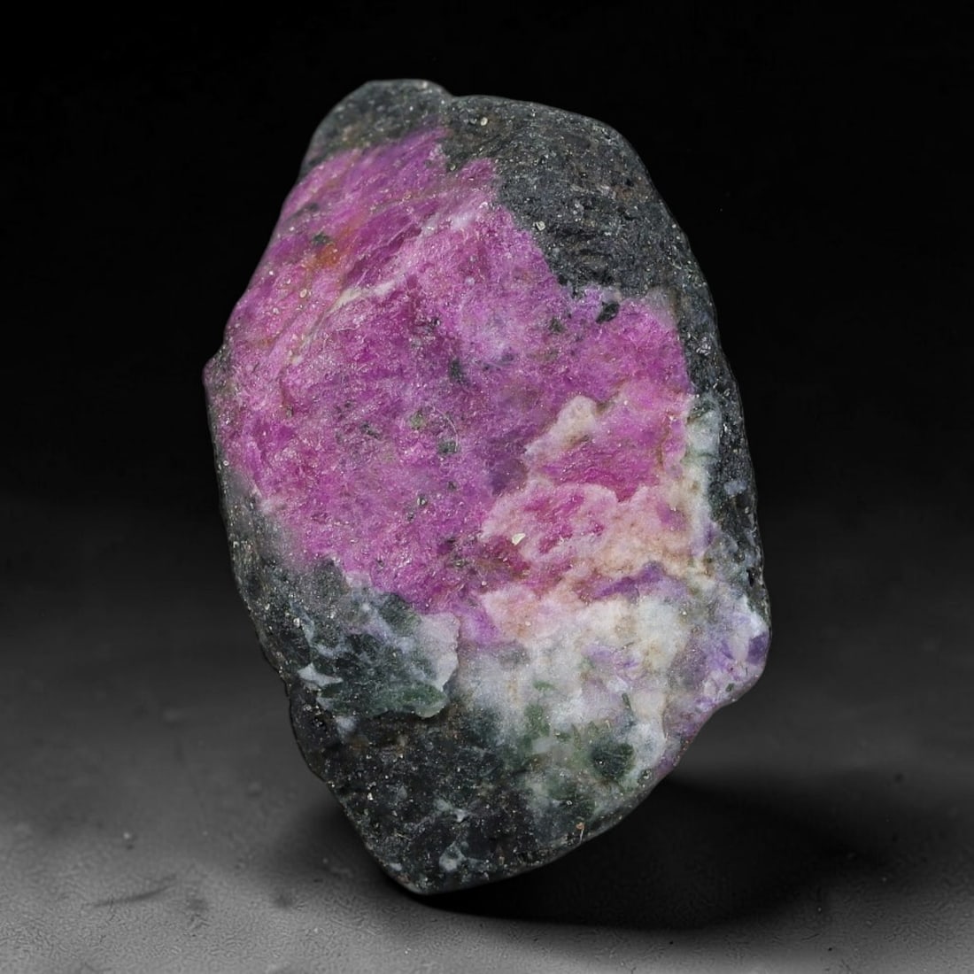 82ct Natural Tanzanian Ruby Zoisite Raw Rough Specimen Mineral Stone, 10YQ: This unpolished mineral rough is natural ruby zoisite sourced from Tanzania, exhibiting distinct banded mineral segregation of vibrant green zoisite, magenta ruby crystals, and dark hornblende inclusi