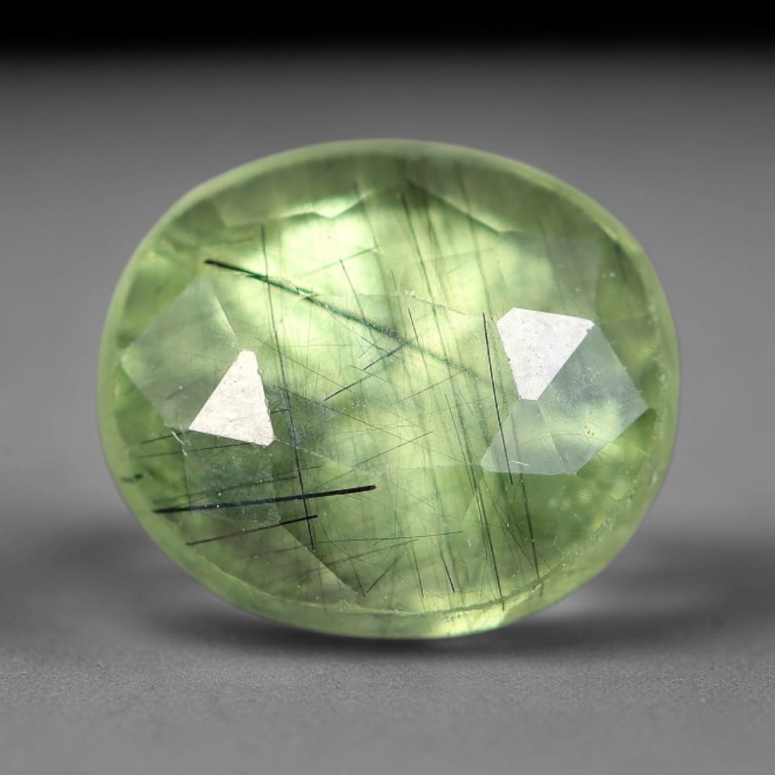 2.21 Carats Natural Green Rutilated Peridot Oval Faceted Loose Gemstone, 74WS: This classic oval faceted peridot features a soft translucent pale olive green crystal filled with striking clusters of dark brown and black rutile needle silk that crisscross throughout the stone, wi