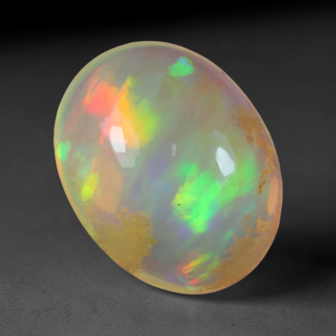 1.86 Carats Natural Ethiopian Welo Opal Oval Cabochon Loose Gemstone, 49XV: Natural Ethiopian Welo opal polished oval cabochon loose gemstone, luminous translucent milky white base stone with vivid multi-hued play-of-color featuring bright emerald green, lime yellow, soft blu