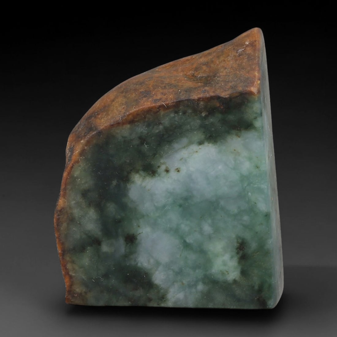 500ct Natural Type A Burmese Jadeite Jade Sliced Rough, 21YR: This specimen is a sliced rough block of natural Type A Burmese jadeite jade. The interior displays natural colour zoning with visible mineral veining and crystalline patterns typical of unprocessed j