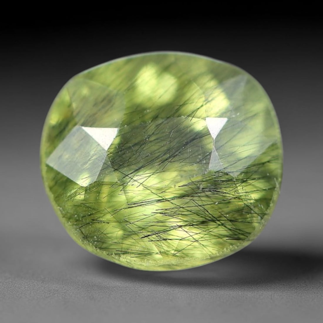 1.58 Carats Natural Green Rutilated Peridot Oval Faceted Loose Gemstone, 71WS: This classic oval faceted peridot features a soft translucent pale olive green crystal filled with striking clusters of dark brown and black rutile needle silk that crisscross throughout the stone, wi