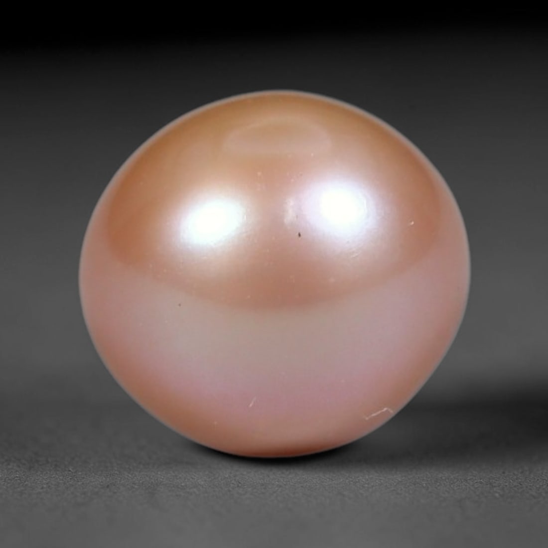 3.40ct Natural Round Freshwater Peach Pink Pearl Loose Gemstone 7.6mm, 44XZ: Flawless natural undrilled round freshwater pearl, showcasing a smooth symmetrical spherical form with soft gradient peach blush nacre transitioning from warm apricot crown to pale pink base. The pear