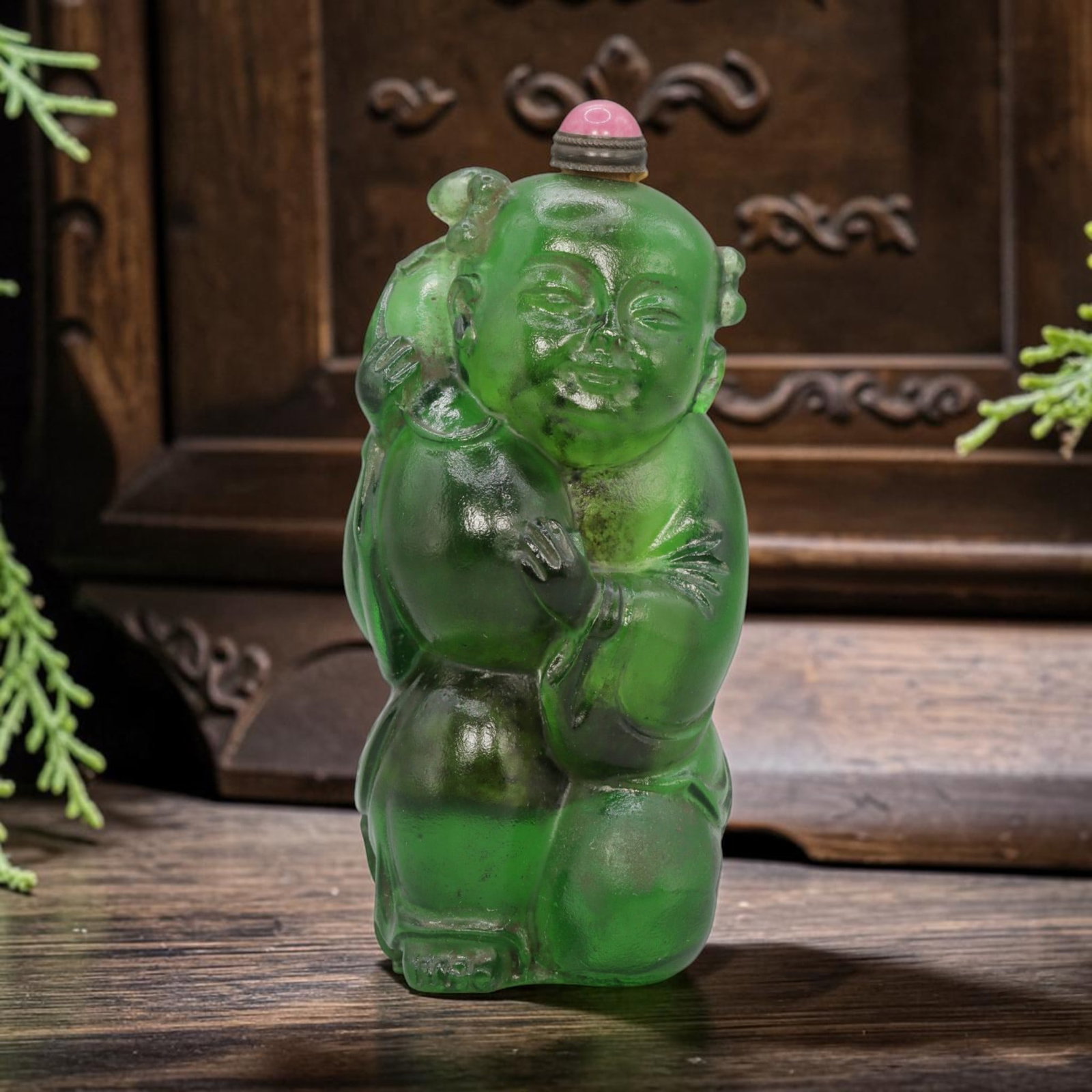Vintage Chinese Green Liuli Snuff Bottle - Child Figure, 75YF: Crafted from translucent emerald-green liuli glass, this snuff bottle depicts a kneeling child figure holding a large gourd, symbolizing prosperity and longevity. The figure features rounded, smooth f