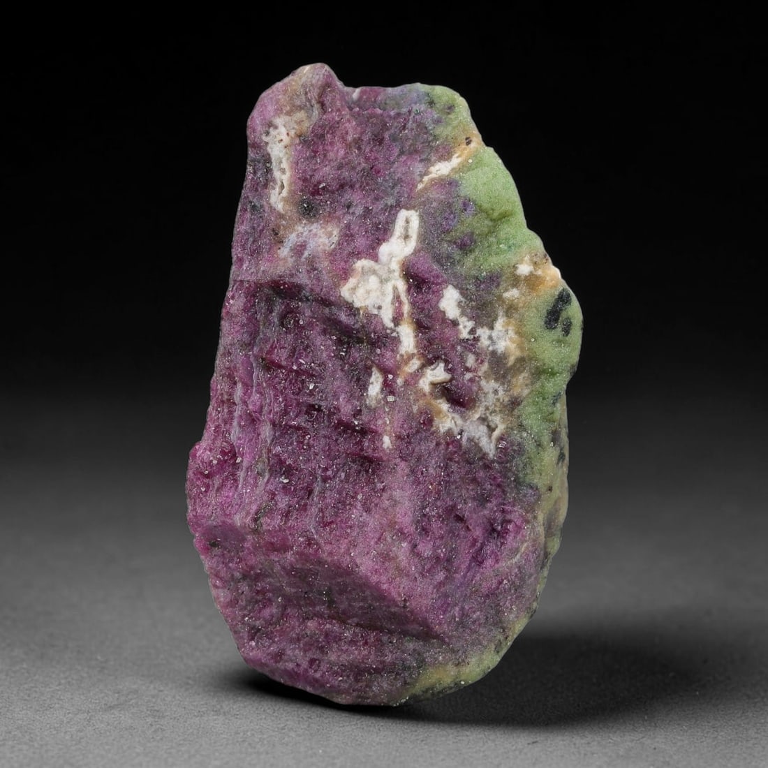 94ct Natural Tanzanian Ruby Zoisite Raw Rough Specimen Mineral Stone, 15YQ: This unpolished mineral rough is natural ruby zoisite sourced from Tanzania, exhibiting distinct banded mineral segregation of vibrant green zoisite, magenta ruby crystals, and dark hornblende inclusi