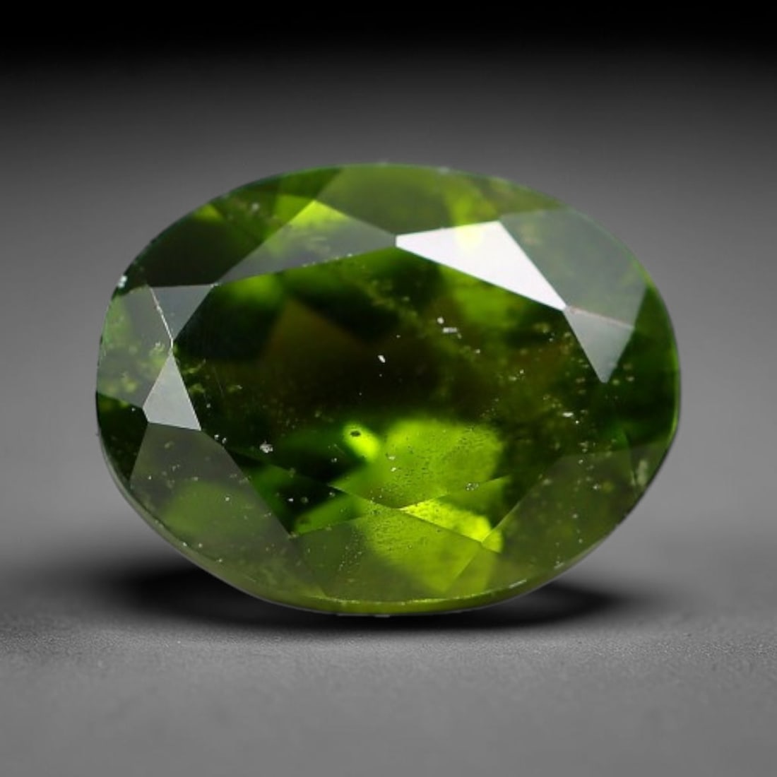 1.40 Carats Natural Vivid Chrome Green Chrome Diopside Oval Faceted Loose Gemstone, 5WJ: This striking chrome diopside faceted oval stone showcases vivid intense chrome green color illuminated through crisp polished step facets, with fine tiny natural mineral speckles visible within the t