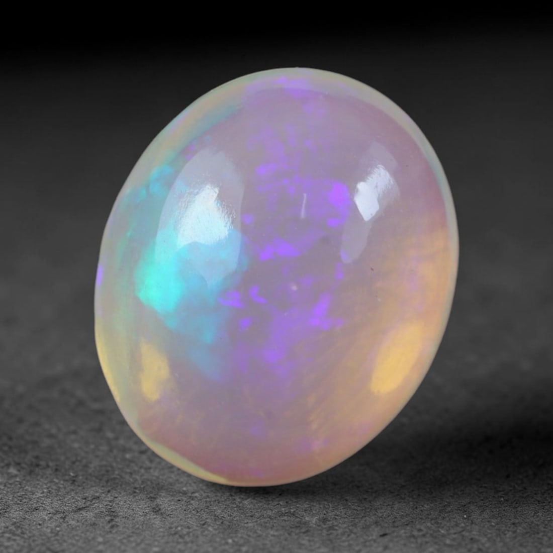 2.24 Carats Natural Ethiopian Welo Opal Oval Cabochon Loose Gemstone, 52XV: Natural Ethiopian Welo opal polished oval cabochon loose gemstone, luminous translucent milky white base stone with vivid multi-hued play-of-color featuring bright emerald green, lime yellow, soft blu