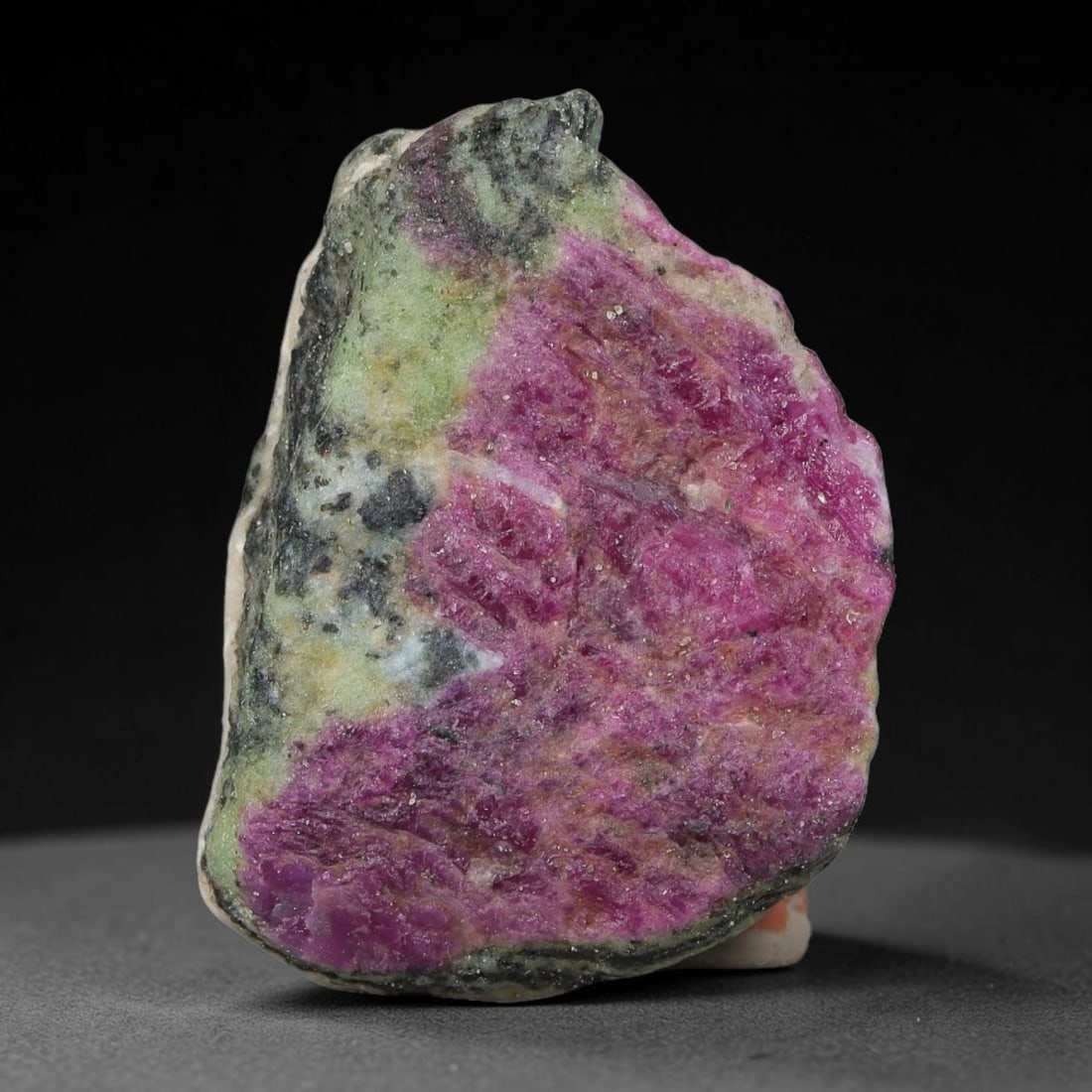 77ct Natural Tanzanian Ruby Zoisite Raw Rough Specimen Mineral Stone, 20YQ: This unpolished mineral rough is natural ruby zoisite sourced from Tanzania, exhibiting distinct banded mineral segregation of vibrant green zoisite, magenta ruby crystals, and dark hornblende inclusi