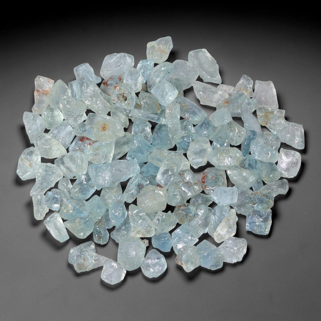 110.72 Carats Natural Aquamarine Rough Parcel, 59WT: This luminous parcel of natural aquamarine rough showcases the classic soft sky-blue hue the gem is known for, ranging from pale, translucent tones to deeper, more saturated blues. The stones are in t