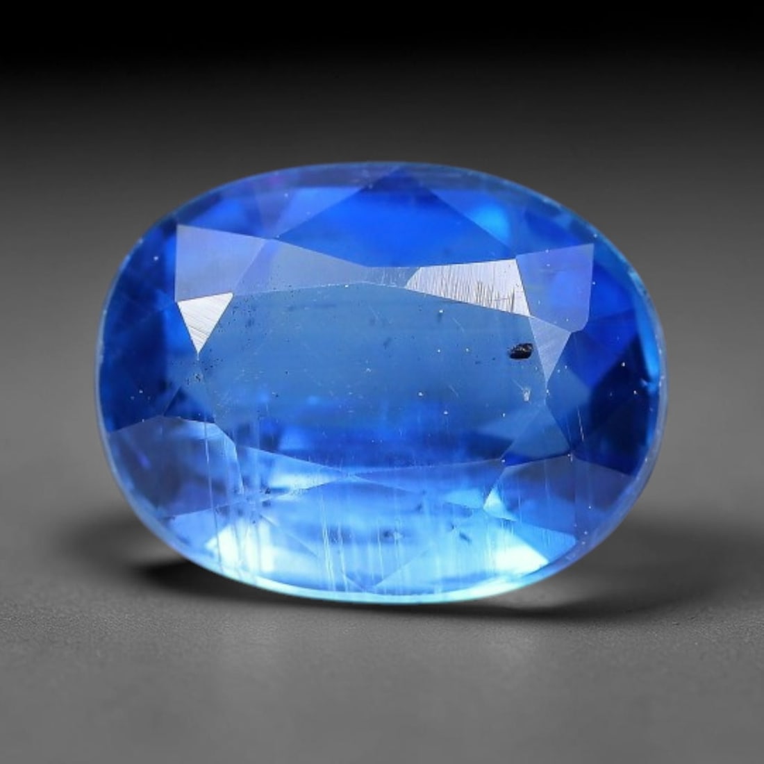 1.55 Carats Natural Brazilian Kyanite Oval Faceted Loose Gemstone, 55XY: This specimen consists of natural kyanite mineral material refined via professional faceted lapidary work, with uniform polished surfaces across the crystal exterior. Natural internal particulate mark