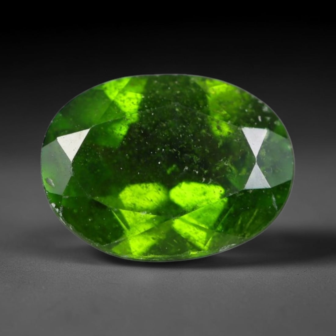 1.28 Carats Natural Vivid Chrome Green Chrome Diopside Oval Faceted Loose Gemstone, 45WS: This striking chrome diopside faceted oval stone showcases vivid intense chrome green color illuminated through crisp polished step facets, with fine tiny natural mineral speckles visible within the t
