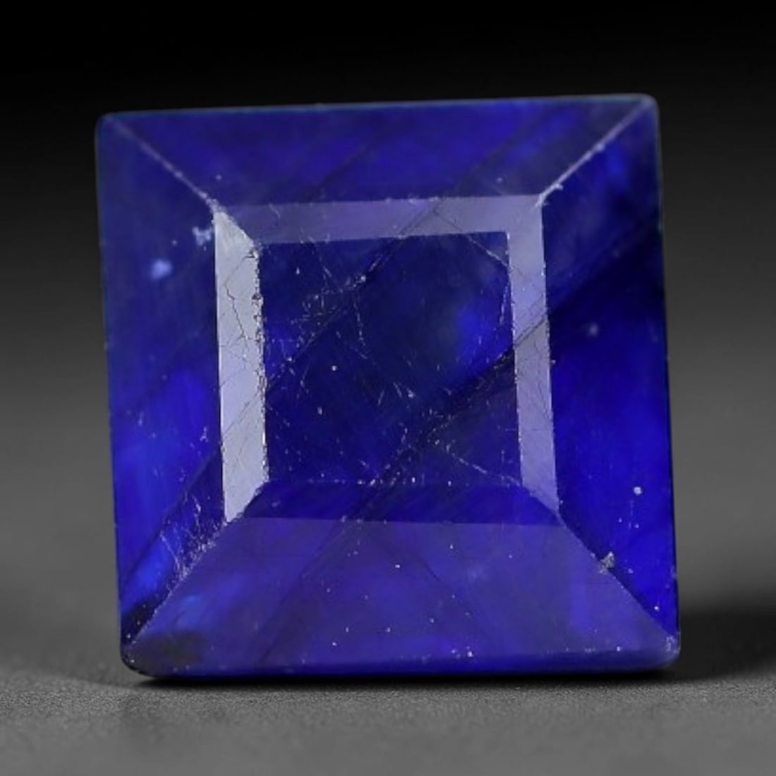 1.81 Carats Royal Blue Sapphire Square Emerald Cut Loose Gemstone, 10WJ: This neat square emerald cut sapphire showcases deep, saturated royal blue color, enhanced by clean reflective step facets. Natural internal fine fissures and scattered tiny mineral specks can be obse